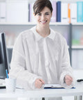 Person wearing 50 Pack Disposable Lab Coats For Adults White Large Bulk With Knitted Cuffs And Collar Ideal For Science Labs