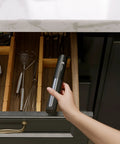 Person placing Usb Rechargeable Milk Frother Handheld 2 In 1 Dual Spring Whisk Electric Frother Wand in kitchen drawer
