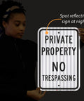 Premium Private Property No Trespassing Sign 12 X 18 Inches Reflective Aluminum held by person, showcasing night visibility.