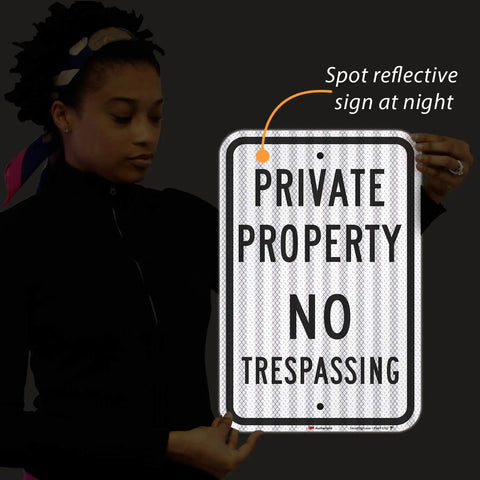 Premium Private Property No Trespassing Sign 12 X 18 Inches Reflective Aluminum held by person, showcasing night visibility.