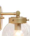 Close-up of hand painted vanity light fixtures with clear globe glass shades, clean lined metal arms showcasing unique finish detail.