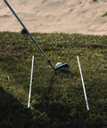 Golf Alignment Sticks 45 Inch Fiberglass Rods Training Aid Set of 2 White placed parallel on grass with golf club and ball.