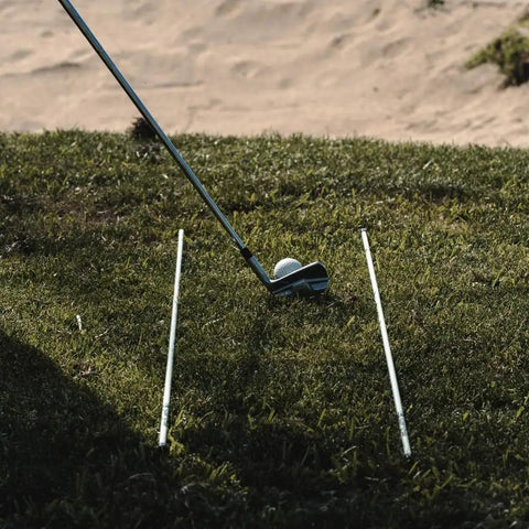 Golf Alignment Sticks 45 Inch Fiberglass Rods Training Aid Set of 2 White placed parallel on grass with golf club and ball.