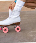 Close-up of white roller skate with 4 pack roller skate wheels with bearings double row outdoor quad skating wheels in pink.