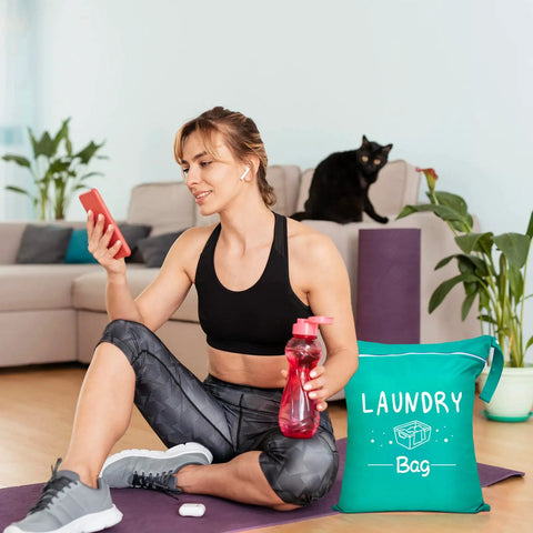 Woman in sportswear with water bottle sitting beside a green Two Pack Large Travel Laundry Bag Waterproof Wet And Dry With Drawstring Closure