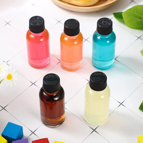 Clear Boston Round Glass Bottles With Black Screw Cap, One Oz Capacity, showing various colorful liquids in a display.