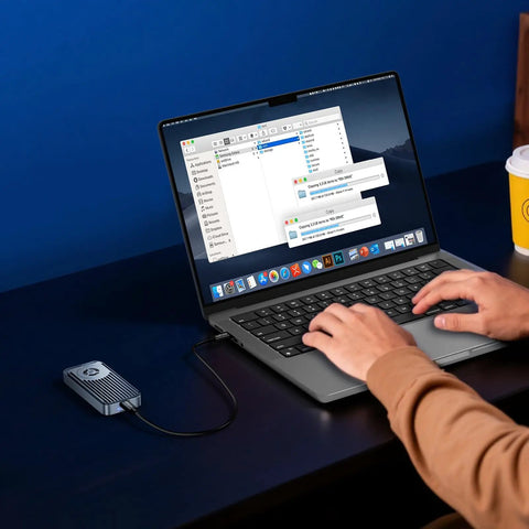 User transferring files on a laptop with Ridiculously Fast M.2 NVMe SSD Enclosure With Built In Quiet Cooling Fan.
