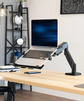 Built Tough Adjustable Laptop Desk Mount For 10 To 15.6 Inch Notebooks With Heavy Duty C Clamp and Grommet Vesa Bracket Support Up To 9.9 Lbs Single Smooth Pivot Arm Matte Black Finish on desk.
