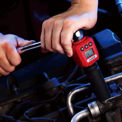 Person using Turn Your Ratchet Into a Legit Digital Torque Tool With Four Units Of Measure on engine, red adapter attached.