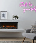 Pink USB Powered Neon Sign For Wall Decor LED Light Neon Art glowing 'Just be yourself' above cozy living room fireplace.