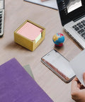Gold Wood Sticky Note Holder for 3x3 Post It Notes on a desk with a laptop and globe