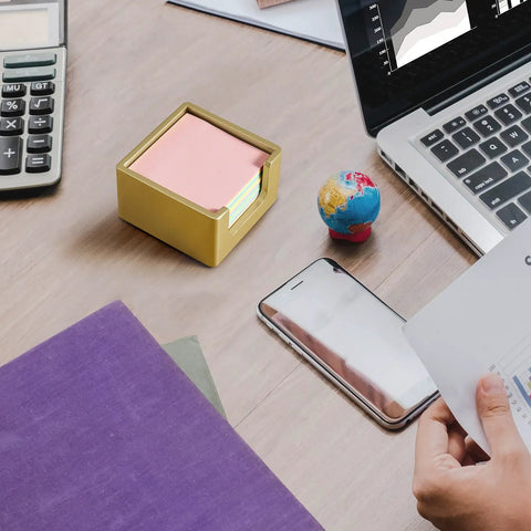 Gold Wood Sticky Note Holder for 3x3 Post It Notes on a desk with a laptop and globe