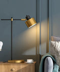 Mid Century Modern Desk Lamp With Matte Black Finish And Gold Accent, Sleek 22.25 Inch Metal Table Light For Home Office Bedroom Study Living Room Nightstand, 5W Bulb Included, next to teal sofa.