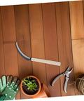 Serrated Weeding Tool With Wooden Handle For Easy Weeding And Harvesting In The Home Garden And Field on wooden deck with gloves.
