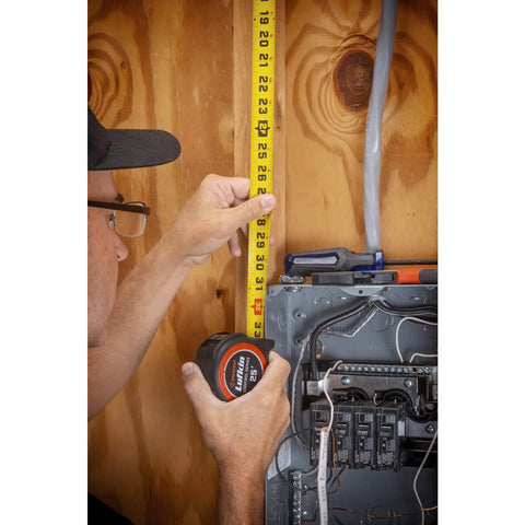 Person using Pro Grade 1-3/16 Inch By 35 Foot Tape Measure With Anti Pinch Retract, Protected Lock Button, on wooden wall