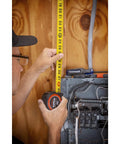 Man using 1-3/16 X 25 Foot Command Control Engineers Tape Measure Yellow Clad With Anti Pinch Lock Button on wall panel