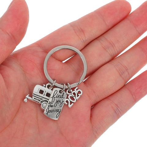 Ultra Lightweight Zinc Alloy RV Key Chain With Travel Themed Design on open palm, featuring camper charm and '2025' tag