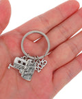 Lightweight Silver Zinc Alloy Camper Keychain With Cute Design on open palm, ideal for RV enthusiasts.