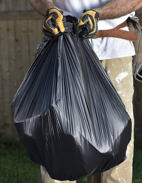 Rock Solid 42 Gallon Heavy Duty Trash Bags Built To Take A Beating 2 Point 5 Mil Thick 32 X 46 Inch Black contractor holding a filled trash bag.