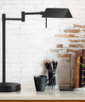 LED Desk Lamp With Full Range Dimming 12W, 1050 Lumens, 360 Degree Swing Arm on a desk, black finish, next to books and plants