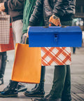 Blue Iron Toolbox With Heavy Duty Lock And Steel Reinforced Corners Comfortable Grip Bar For Hardware Bits Sorting held among shopping bags.