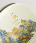 Close-up of Top Shelf Ceramic Tea Tin With Woven Rattan Travel Case, Stunning Mountain Landscape Design in slate blue.