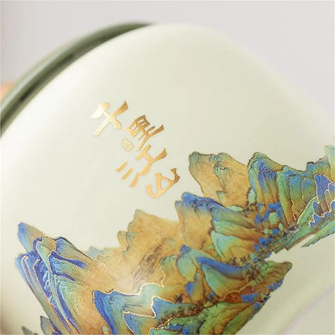 Close-up of Top Shelf Ceramic Tea Tin With Woven Rattan Travel Case, Stunning Mountain Landscape Design in slate blue.