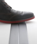 Shoe stepping over Ultra Thin Flat Extension Cord 0.9mm 0.0354 Inch Low Profile Power Cable 6.56 Feet Black under the rug.