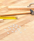 White Shutter Repair Pins, 120 Piece Movable Louver Fasteners on a wooden surface with a tape measure and hammer.
