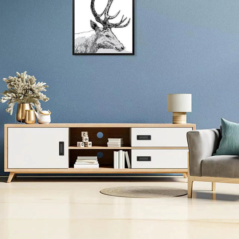 Modern living room with blue wall, white and wood console, black recessed handles, decor items, and artwork on wall.
