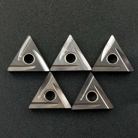 Set of five silver TNMG carbide inserts with central mounting hole for lathe turning