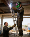 Worker using auto darkening welding helmet with air system and true color viewing shield for industrial metalworking safety.