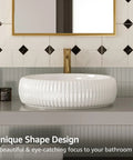 White porcelain vessel sink on a bathroom vanity with textured design, gold faucet, and geometric tile background.