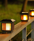 4 Pack Solar Flame Post Lights for Wood Fence Posts illuminating at night, showcasing flickering flame bulbs on wooden posts.
