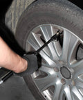 Front view of WYNNsky heavy-duty dual-head air pressure gauge with extended tube attached to a car tire valve