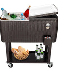 Portable Patio Cooler Bar Cart 80QT Rolling Beverage Station With Storage Shelf Lockable Wheels and Bottle Opener, rattan design, filled with drinks and ice, shelf with bread and bottles.
