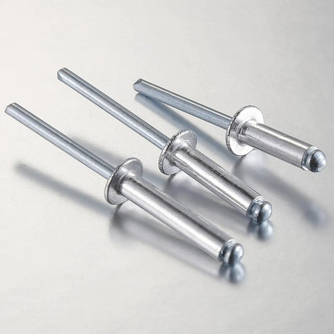 Close-up of Pro Grade Aluminum Blind Rivets Kit With Aluminum Grip And Steel Mandrel Set 80 Piece Fasteners Pack For Home DIY Projects Durable Corrosion Resistant Aluminum Rivets For Indoor And Outdoor Use on metal surface, showing three rivets angled left, highlighting aluminum body and steel mandrel.