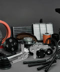 Assorted automotive engine components including filters, gears, and metal parts displayed on a surface.