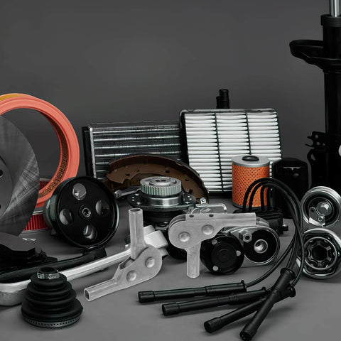 Assorted automotive engine components including filters, gears, and metal parts displayed on a surface.