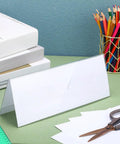 30 Pack Clear Plastic Name Tent Holders For Desk 11 Inch By 4.25 Inch Acrylic Name Plates on an office table with accessories