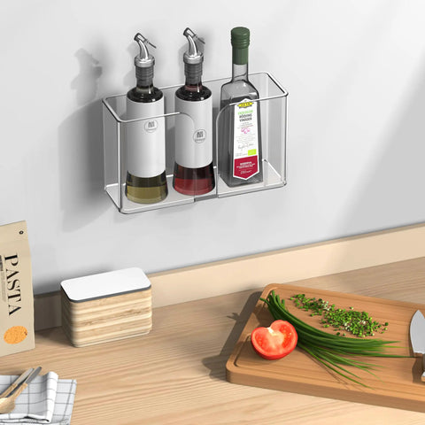 Wall-mounted clear acrylic rack holding three condiment bottles in a kitchen setting with cutting board and spice container.