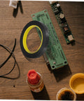 One Roll Blackout Tape For Windows That Blocks LED Light And Dims Screens resting on a wooden table with electronic components