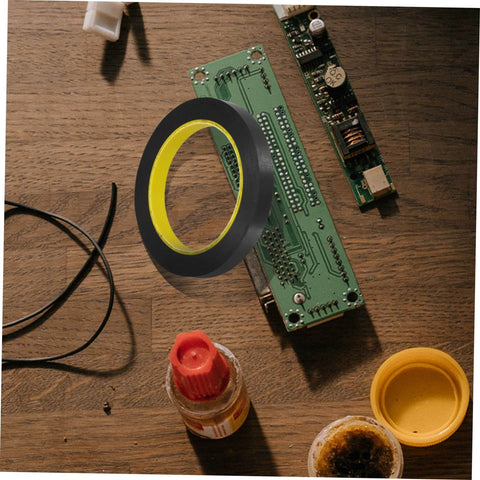 One Roll Blackout Tape For Windows That Blocks LED Light And Dims Screens resting on a wooden table with electronic components