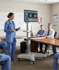 Adjustable Height Rolling Standing Desk With Rock Solid Monitor Mount And Smooth Keyboard Tray in a medical meeting room.