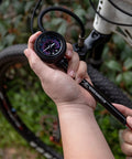 Person using high pressure bike shock pump with no loss Schrader valve for front fork and rear suspension 400 PSI gauge.