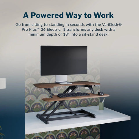 Vari Pro Plus 36 Electric Standing Desk Converter in stylish walnut finish, adjustable height, dual monitor setup.