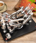Heavy Duty Four Cylinder Stirling Engine Model In Atmospheric Black With Solid Brass Drive Train and Smooth Flywheel Motion on wooden desk.
