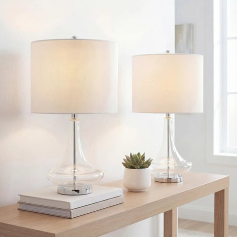 Teardrop Glass Table Lamps Set Of 2 With Clear And Chrome Finish on a wooden table, featuring white linen drum shades