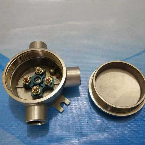 Front view of stainless steel explosion-proof junction box with cover removed; blue terminal block inside.