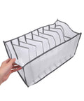 Total Closet Game Changer 3 Pack Seven Grid Foldable Bins With Grippy Handles, white fabric bin with dividers in hand.